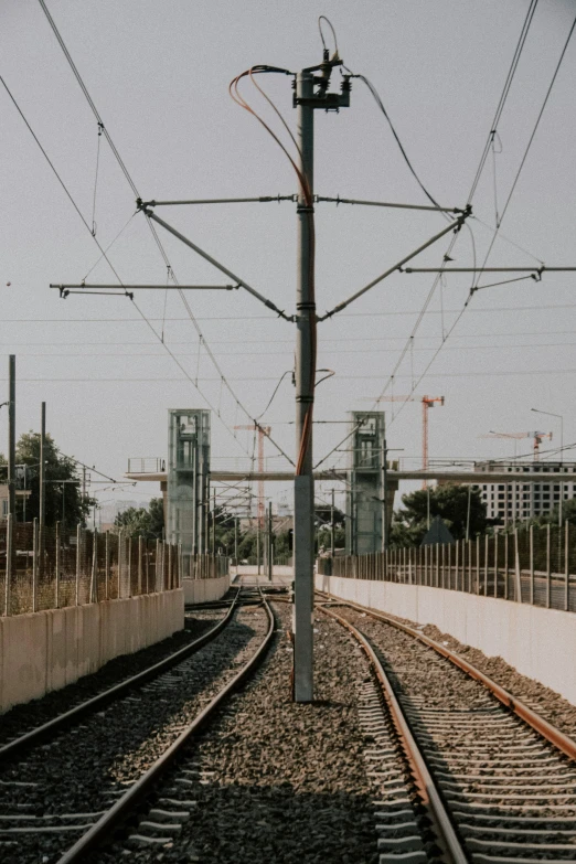 an empty train track with power lines and power towers