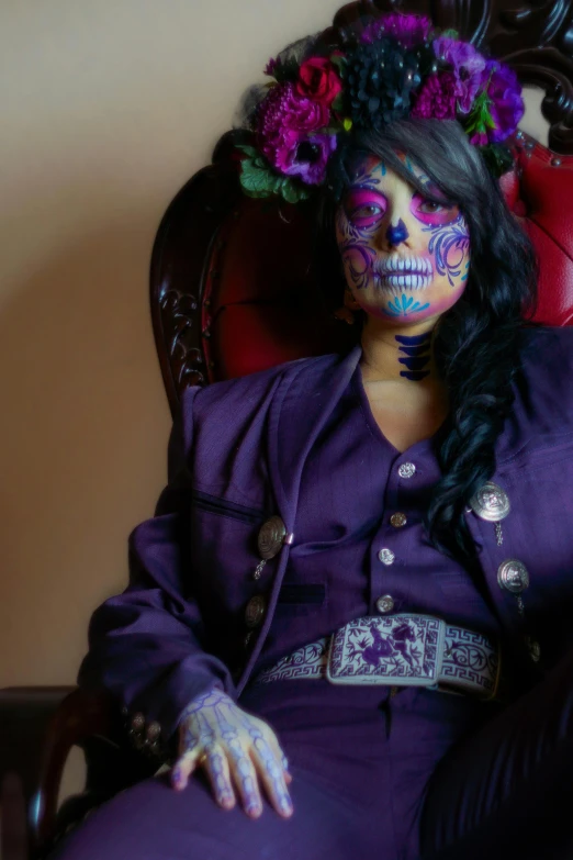 a woman with her face painted is sitting in a chair