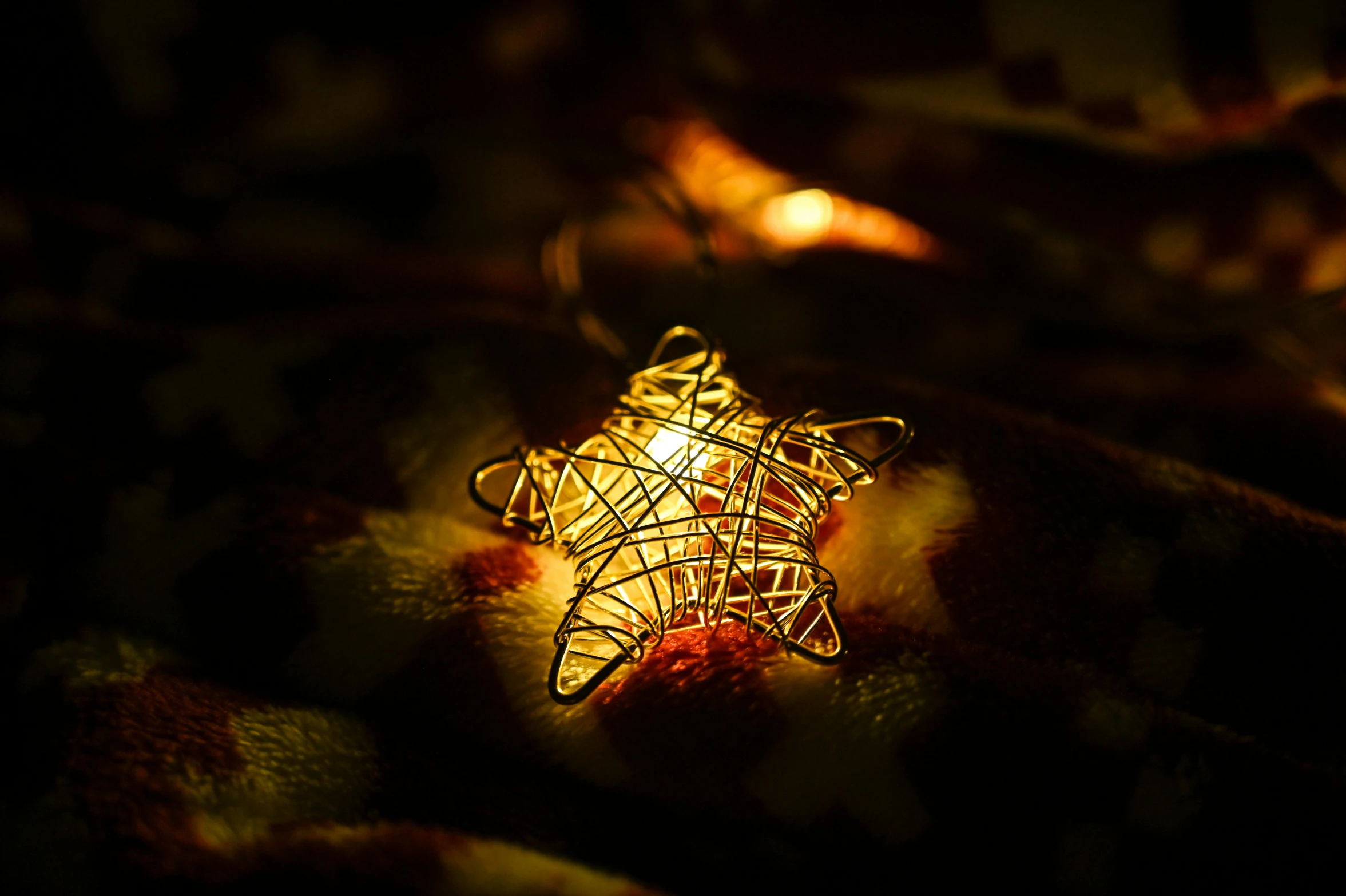 a lighted christmas star ornament on a blanket