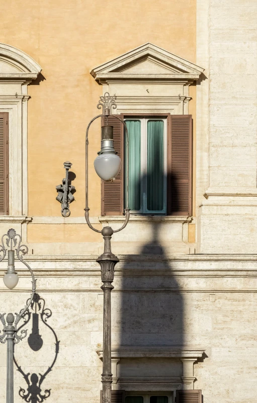 a tan building has two windows and a street light