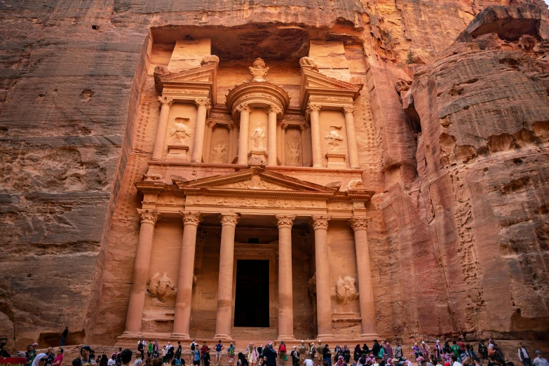 tourists flock around the building, including a tourist information stand