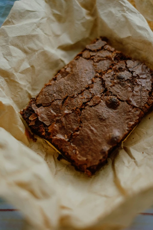 a pastry is in brown paper on top of a table