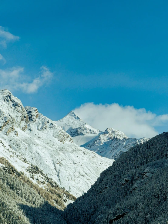 two snow - covered mountains in the distance with a cloudy sky