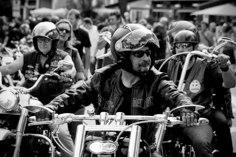 black and white po of two people on a motorcycle with other people
