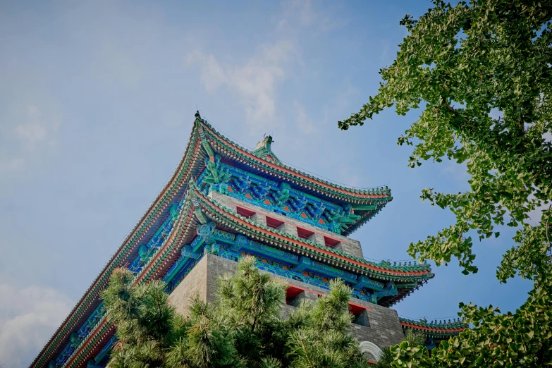 some trees and a blue tower with a sky background