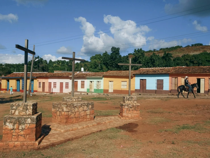 a horse walks by small adobe style buildings