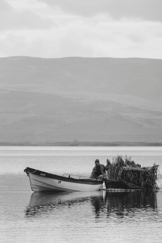 a small boat with a man sitting on top in the water