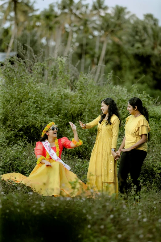 a beautiful young woman sitting on the ground next to other women