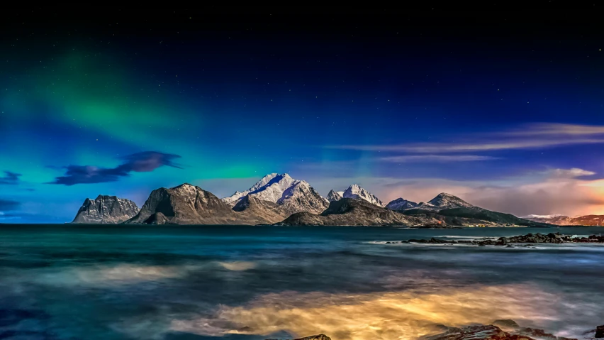 a landscape with water and mountains covered in a colorful aurora lighting