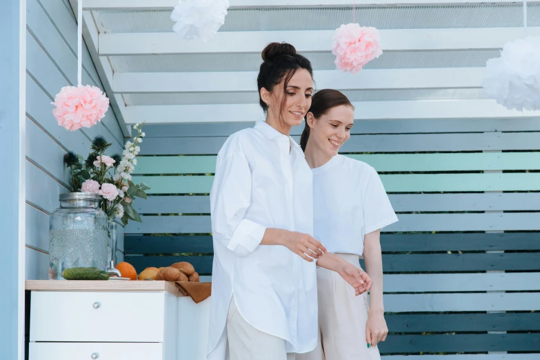 two women who are standing in the kitchen together