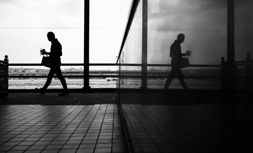 two people walking beside the water on a foggy day