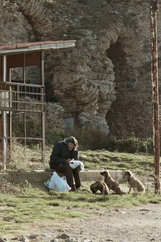 a person sits outside on a stone bench as they collect soing