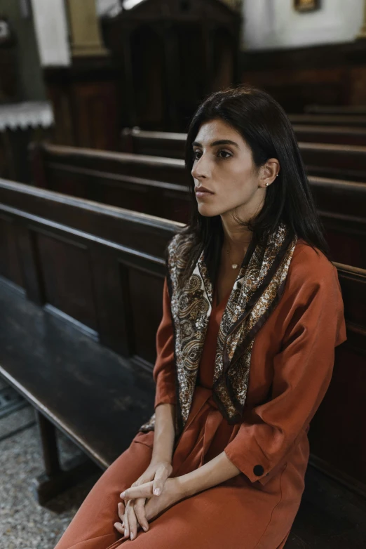 a woman is sitting on the pew of a church