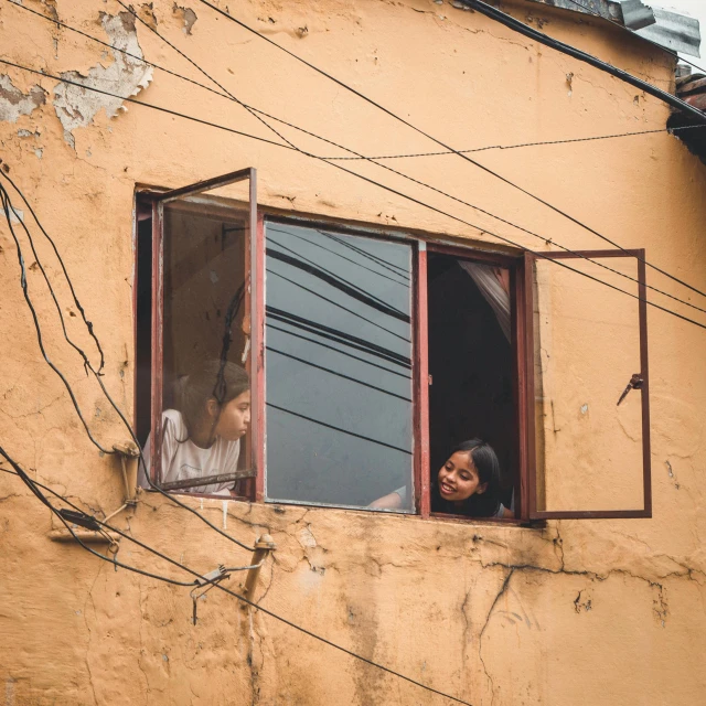 a woman looking out of a broken window