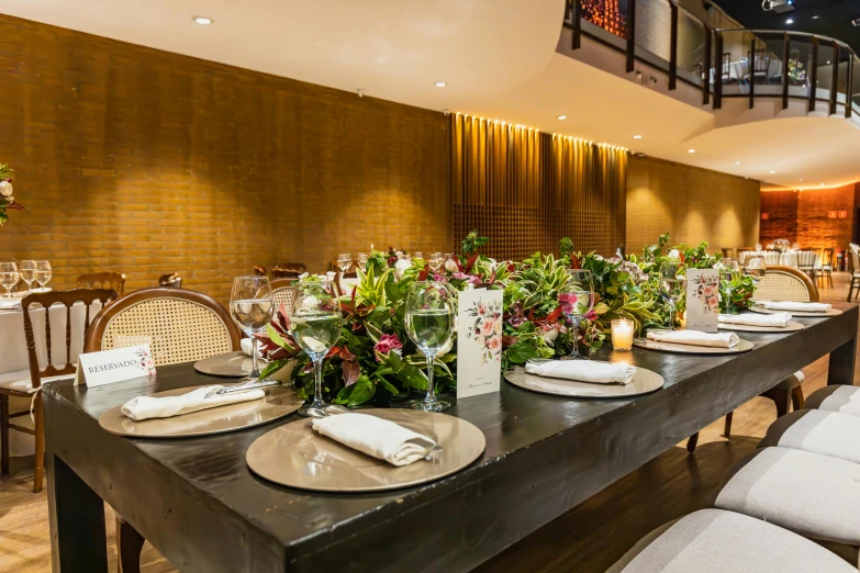 a table with place settings and flowers at it