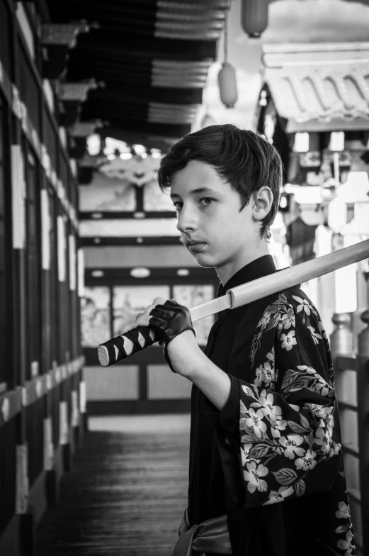 a boy wearing a kimono holding a wooden baseball bat