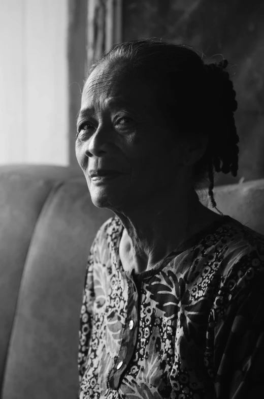 a woman sitting on top of a couch next to a wall