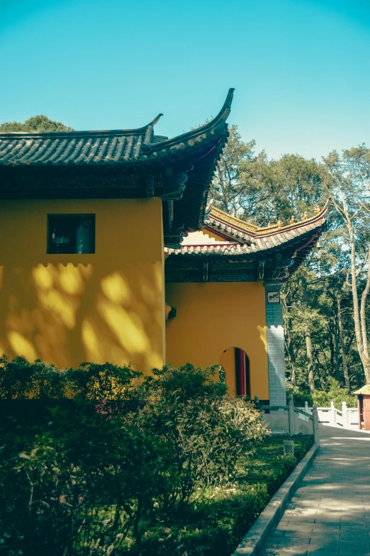 a yellow building with a small red door and windows