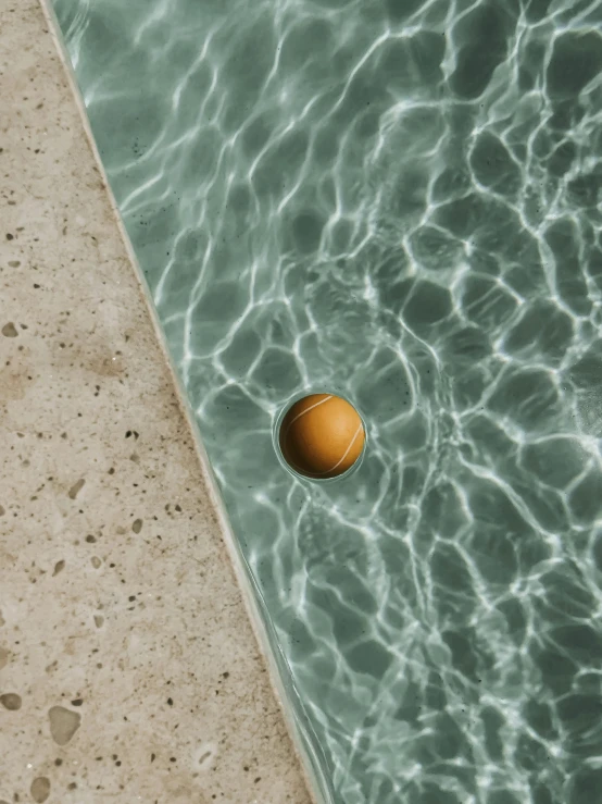 a tennis ball that is floating in some water