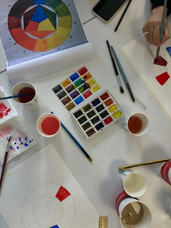 several paints and cups sit on a table
