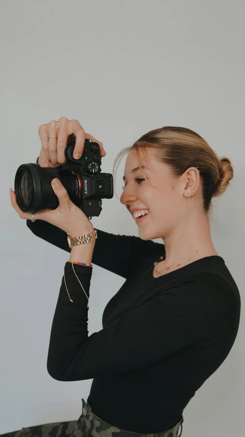 a woman holds a camera up to take a po