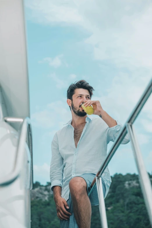 a man sitting on a staircase drinking soing