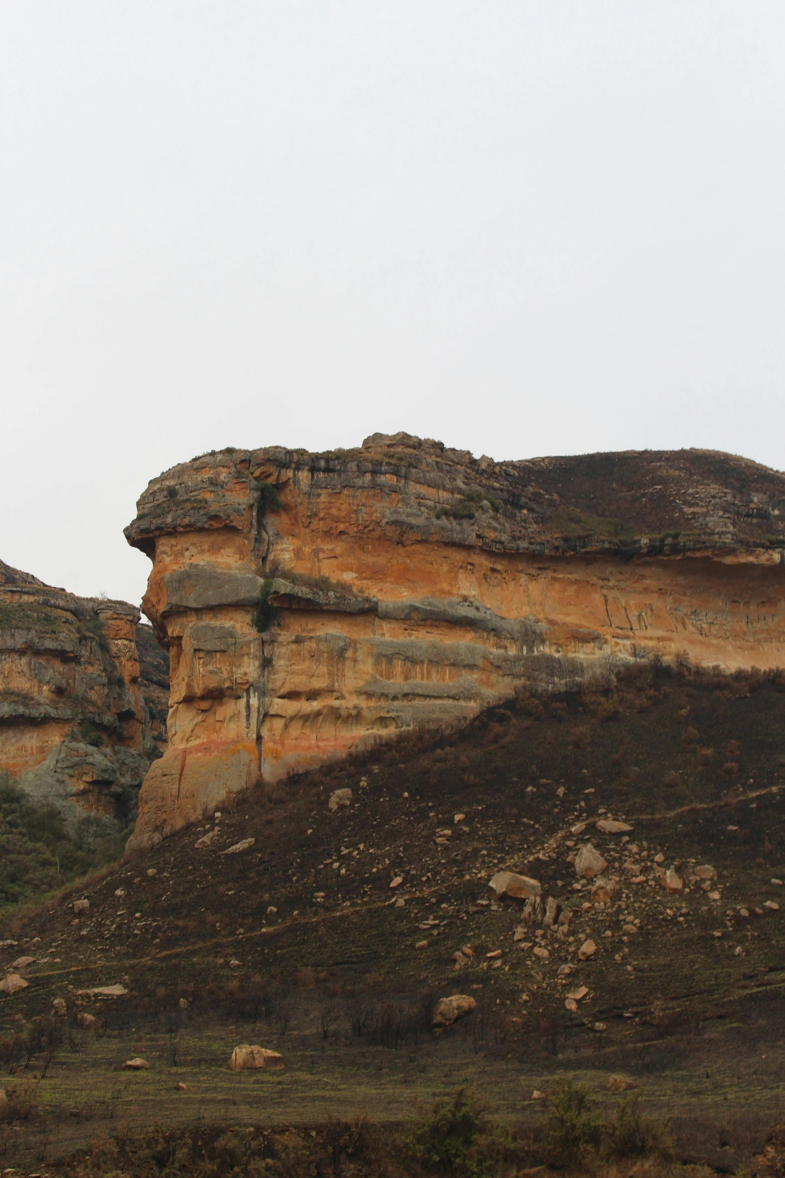 a large rock face next to some hills