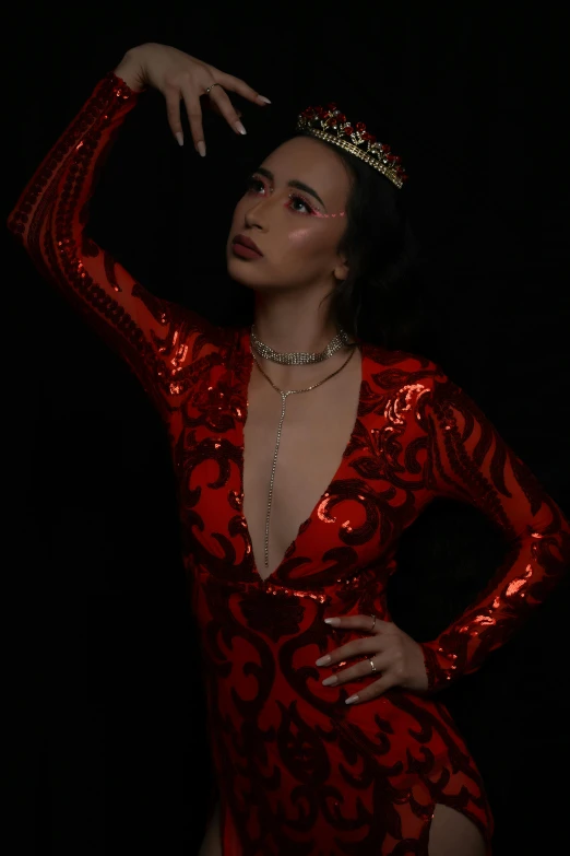 woman dressed in red with black background in front of camera