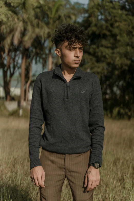 a man standing in a field with trees