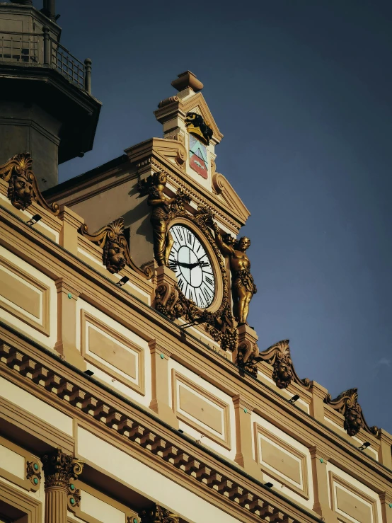 a gold and white building has a large clock on the top