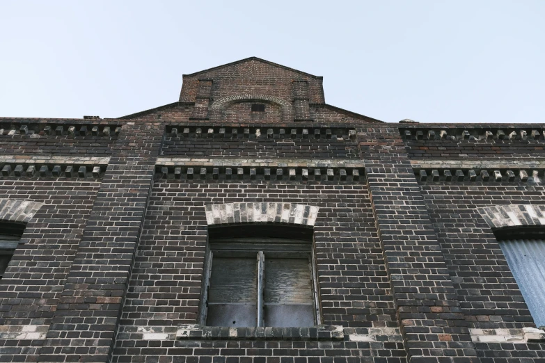 a brick building has two windows and a window frame