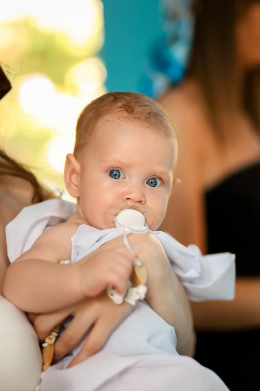 a baby being held by a mother holding her