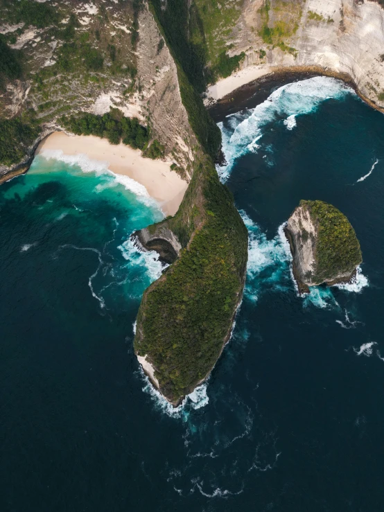 three different rocks in a body of water near some land