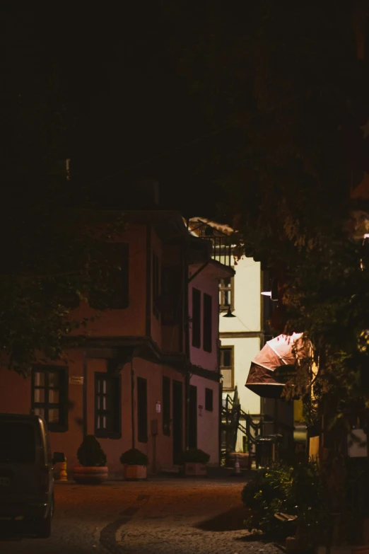 a very pretty house at night with some umbrellas on the front