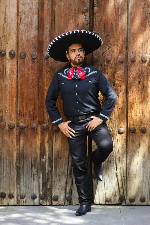 the man is dressed in black and a large sombrero