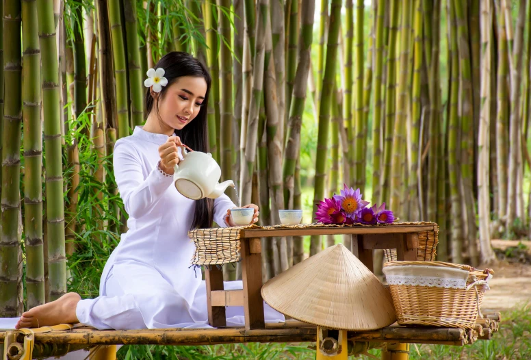 a woman sitting on a bench drinking from a tea pot