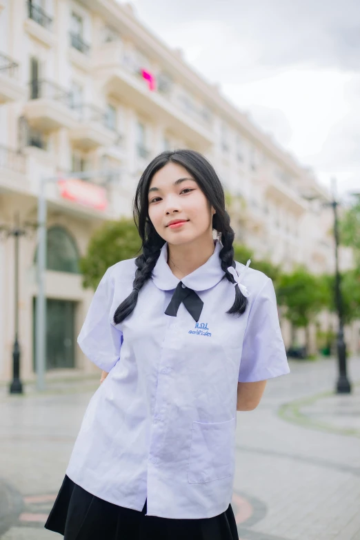 a girl standing on a sidewalk in a school uniform