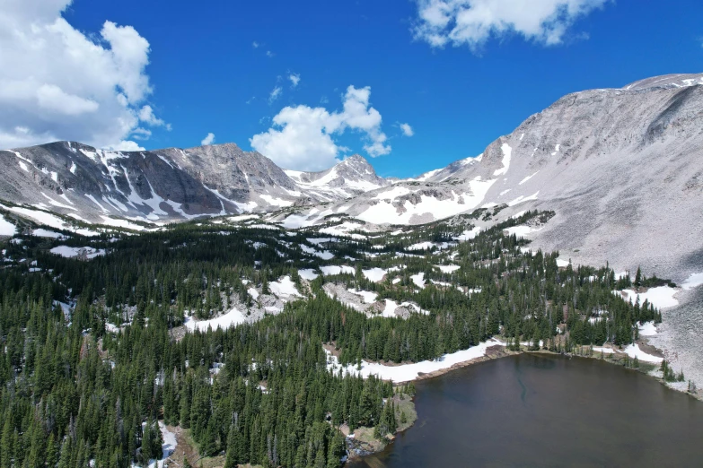 a mountain landscape shows snow covered mountains and a lake