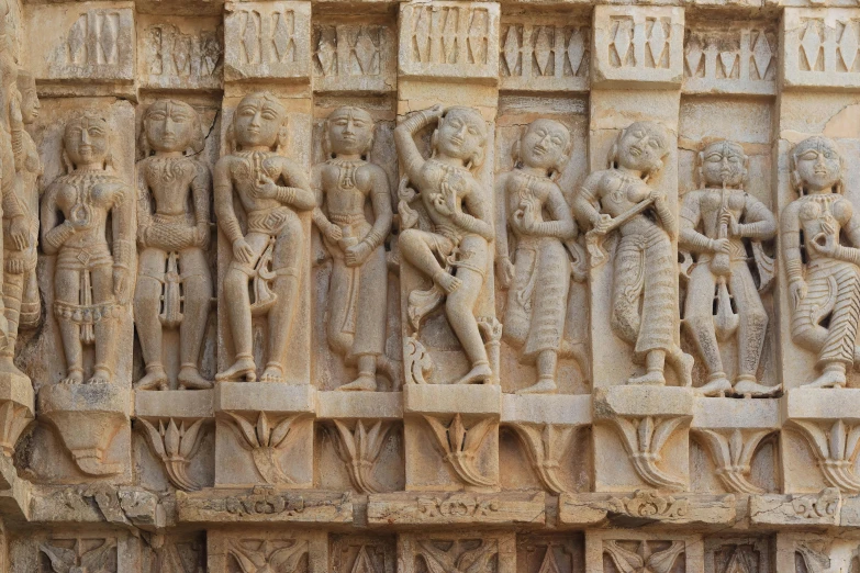 an intricate stone sculpture depicting people holding spears