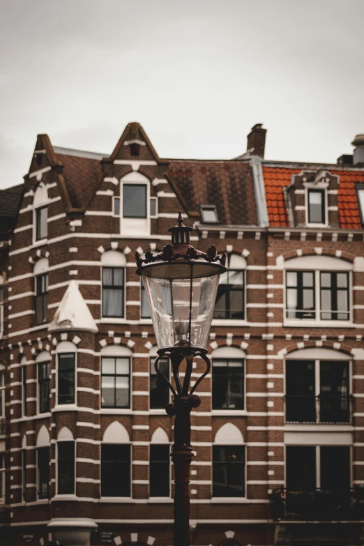 a lamp post in front of a brick building