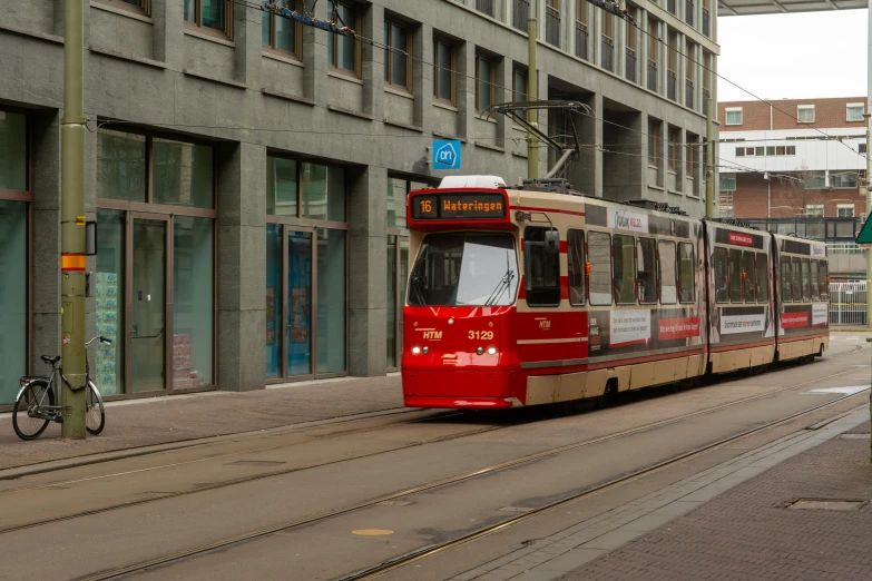 a red and white trolley traveling down a road