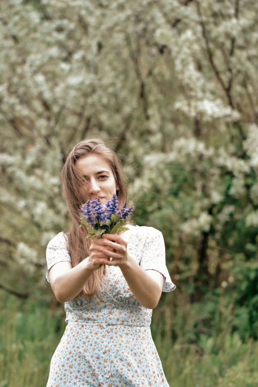 a  holds flowers up to her mouth