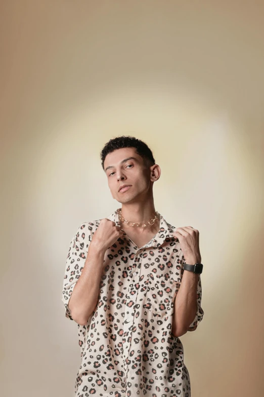 a man in a dress shirt is posing with his hand on his tie