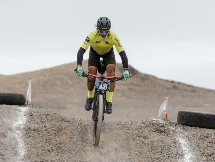 the man is riding a bike on a dirt track