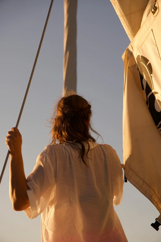 a woman holding onto an outside sail