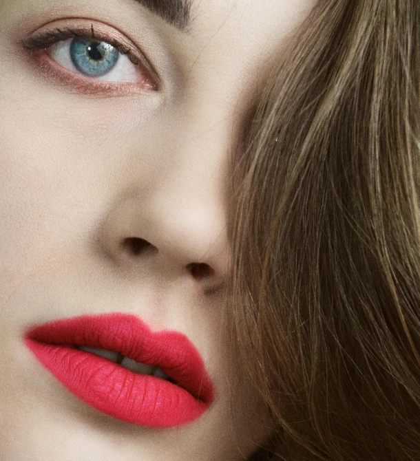 a beautiful young lady with red lips is looking straight ahead