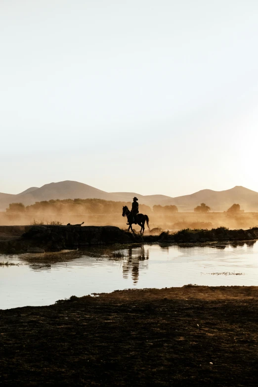 a person on horseback rides across a body of water