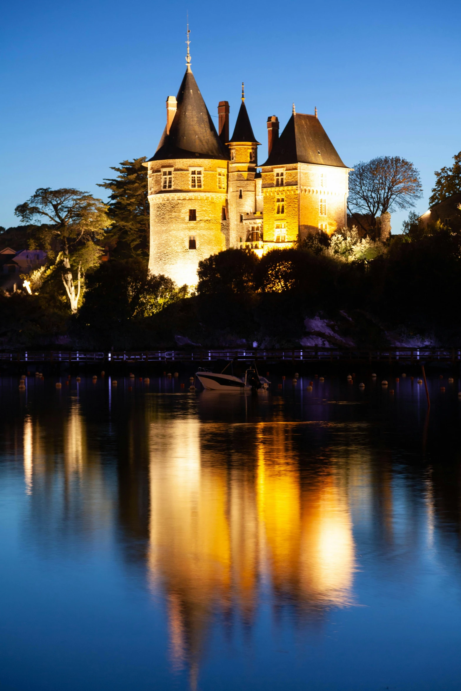 a castle with the lights reflecting in the water