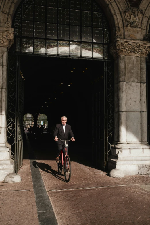 a man riding on the back of a bicycle through a tunnel