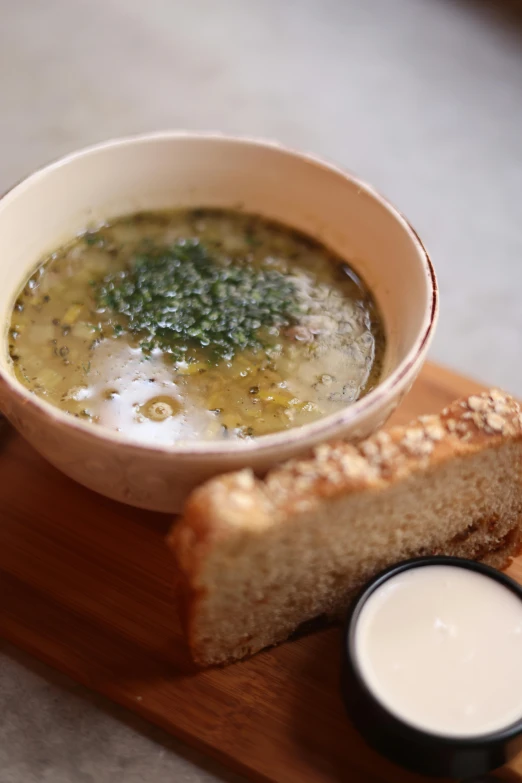 a bowl of soup on top of a  board with a spoon